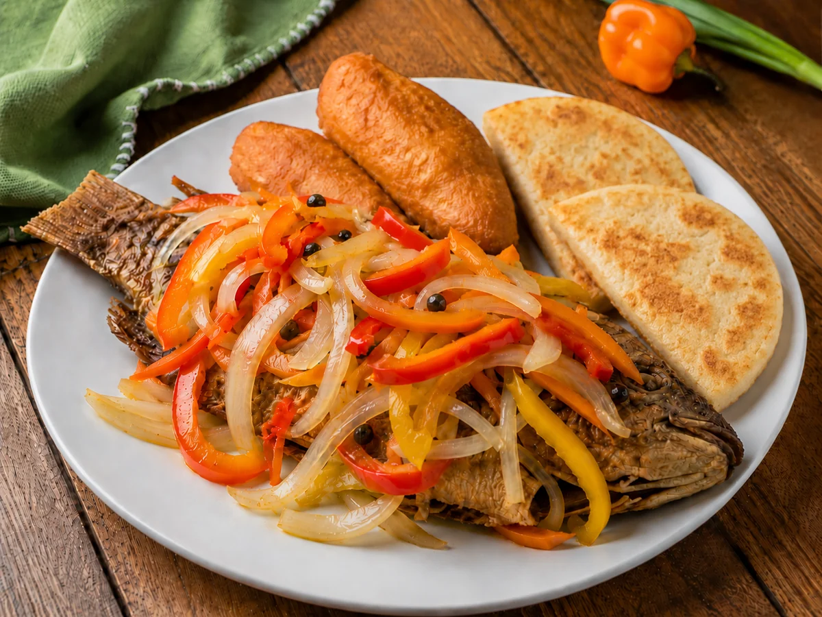 Jamaican escovitch fish served with pickled vegetables, festival and fried bammy.